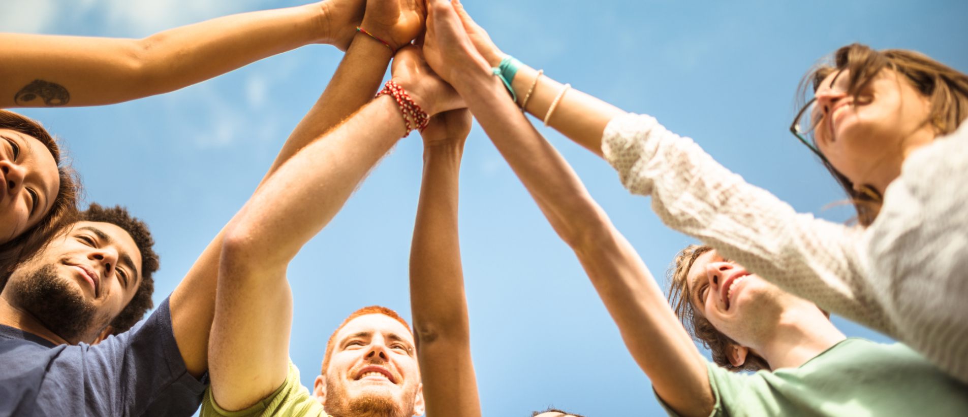 A group of people holding their arms up and joining hands in solidarity