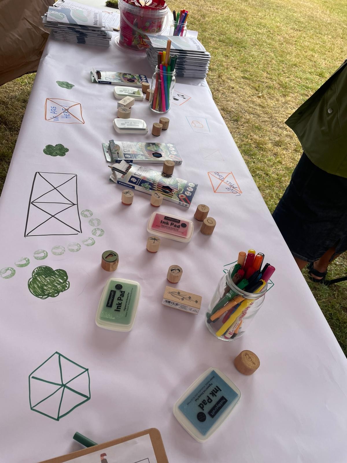 A table loaded with items for map making - pens, pencils, notebooks
