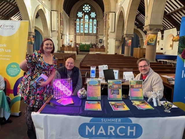 Happy volunteer fair stallholders ready to welcome visitors.