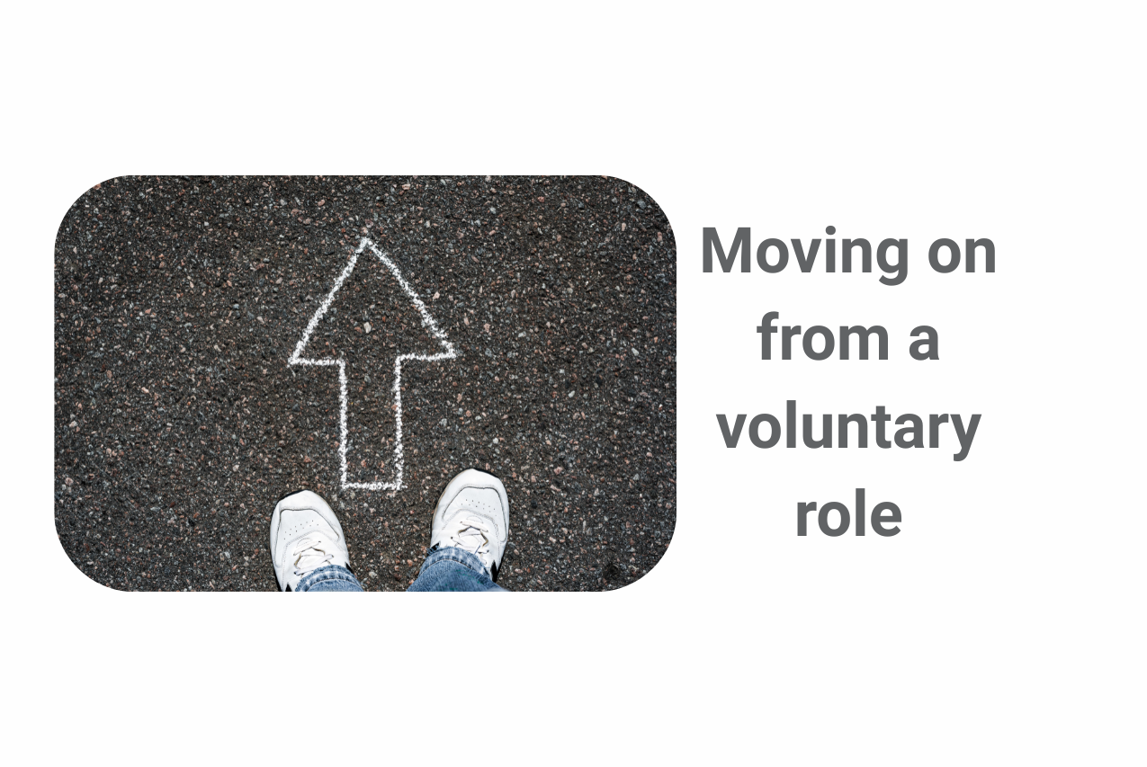 A pair of feet wearing white trainers on a pavement pointing the same way as a white arrow on the ground